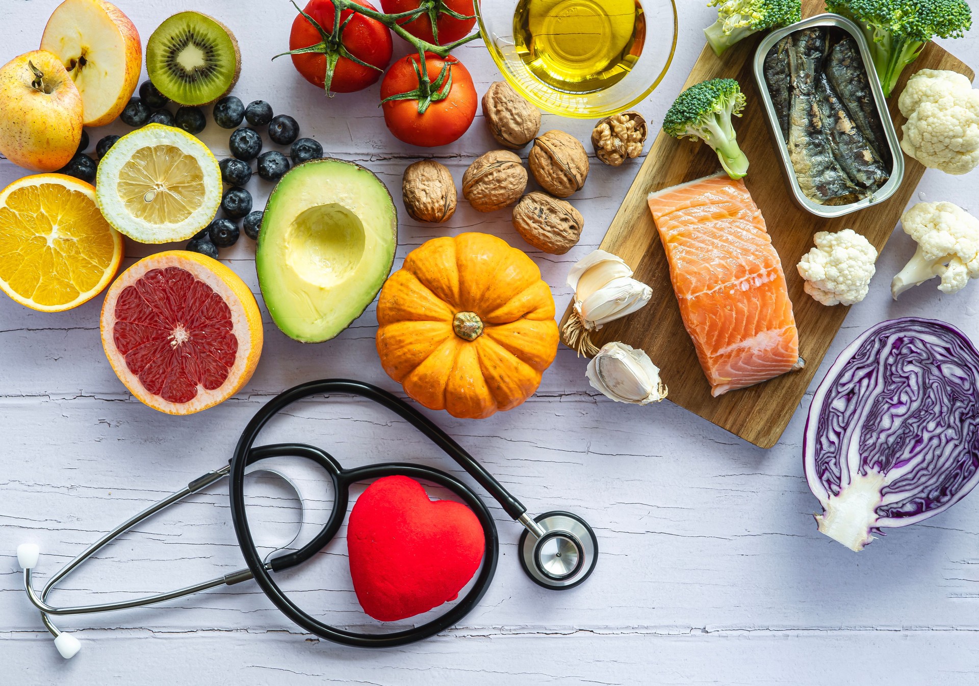 Stethoscope and a heart surrounded by healthy food: fruit, vegetables, fish. Healthy food concept to prevent diseases